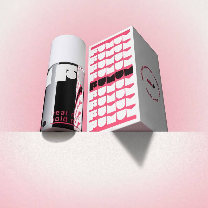 Perfume and box with 'Fumum' branding on a light pink background