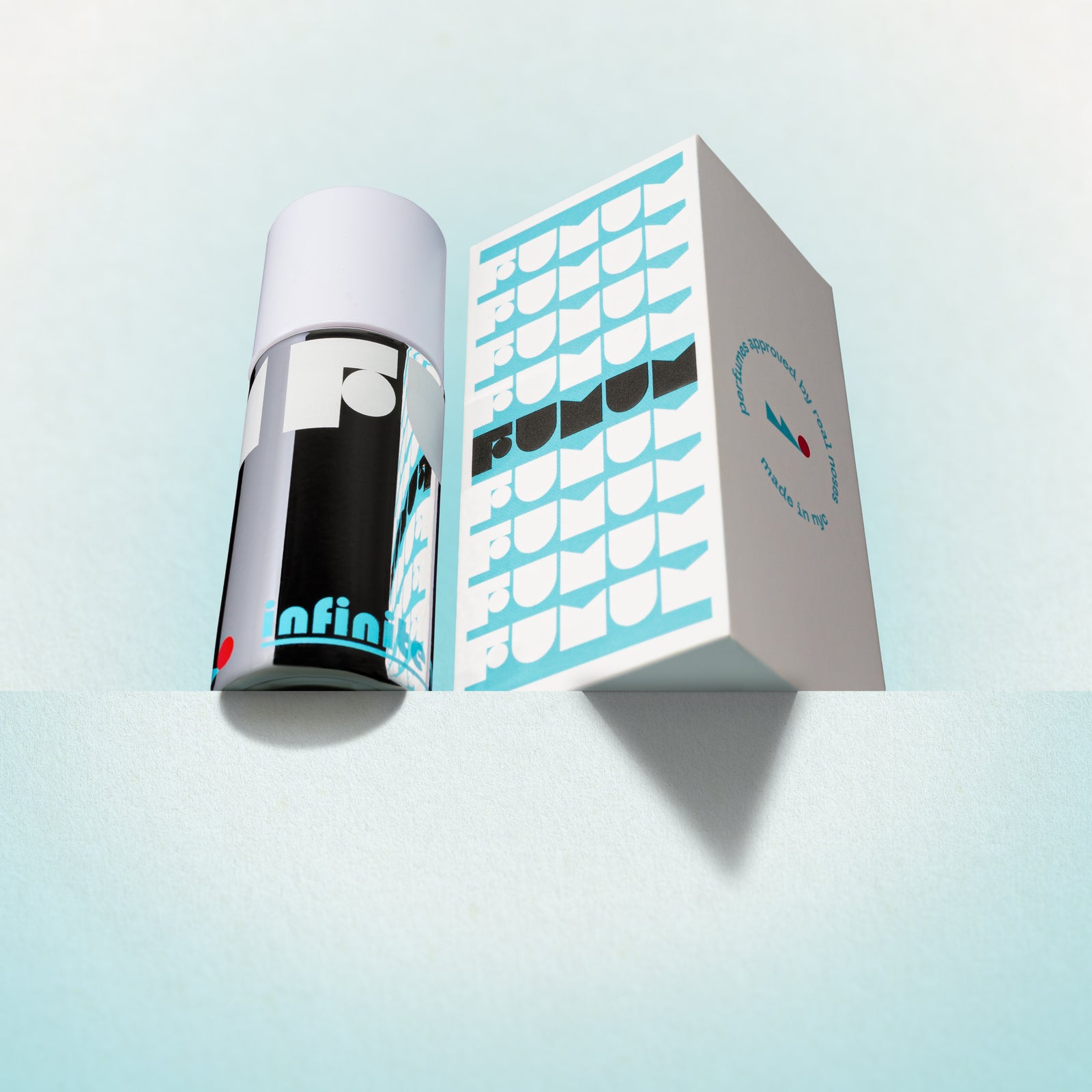 Perfume and box with 'Fumum' branding on a light blue background