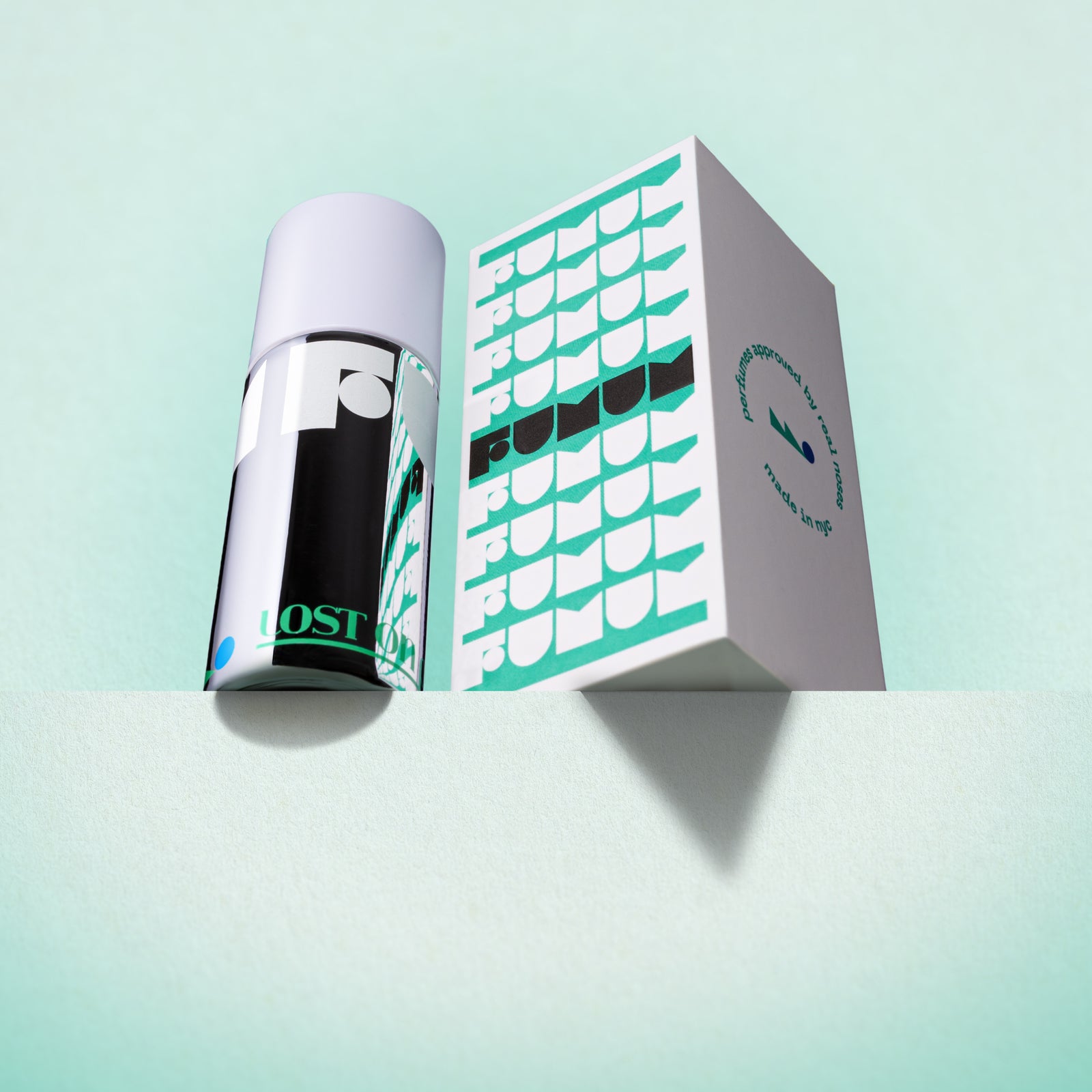 Perfume and box with 'Fumum' branding on a light blue background