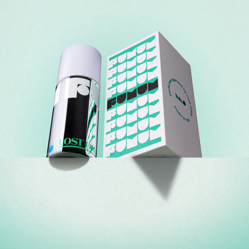 Perfume and box with 'Fumum' branding on a light blue background