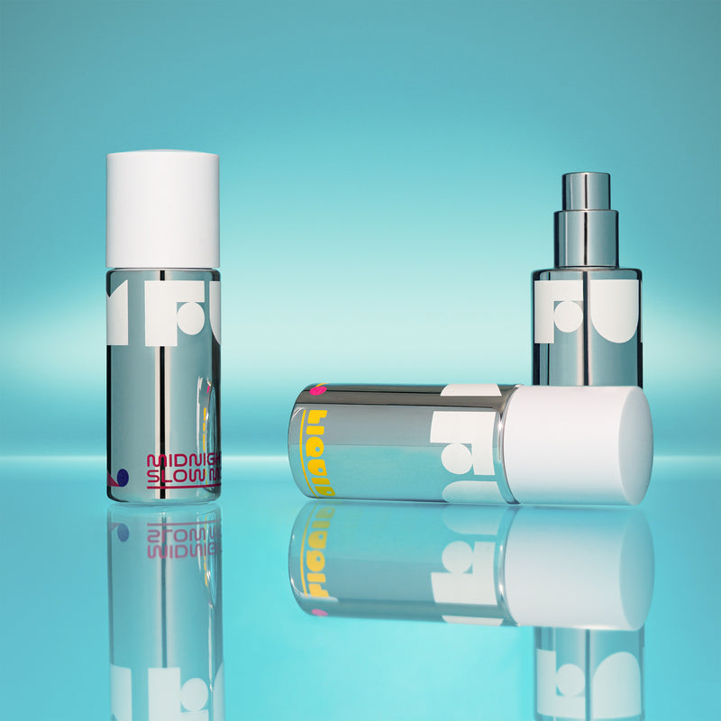 Three skincare bottles with visible branding on a reflective surface and blue gradient background