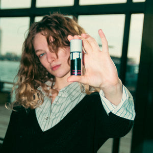 Person holding a cylindrical product with a blurred background