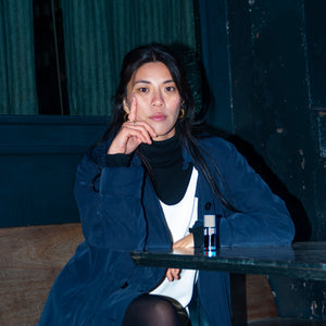 Person sitting at a table with a bottle of water in a dimly lit room