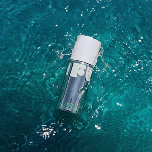 Clear bottle with white cap floating on turquoise water